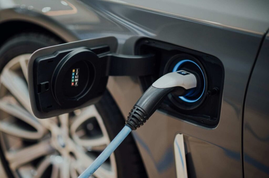 A black electric car getting charged.