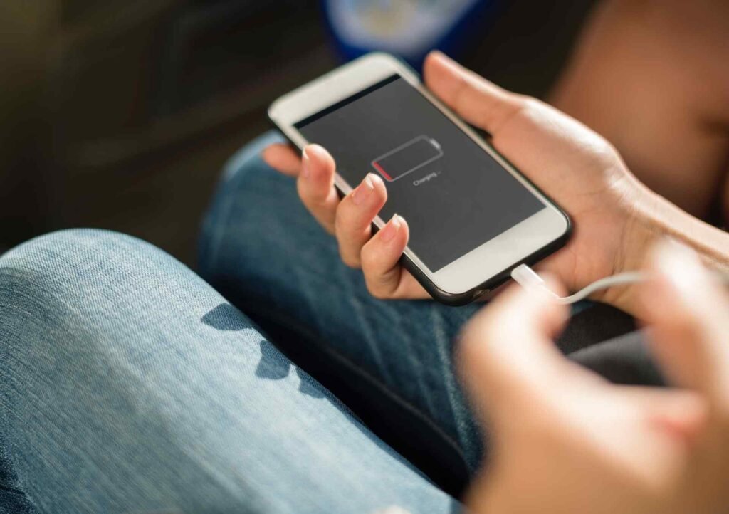 A smartphone getting charged on very low power while a person is holding it.