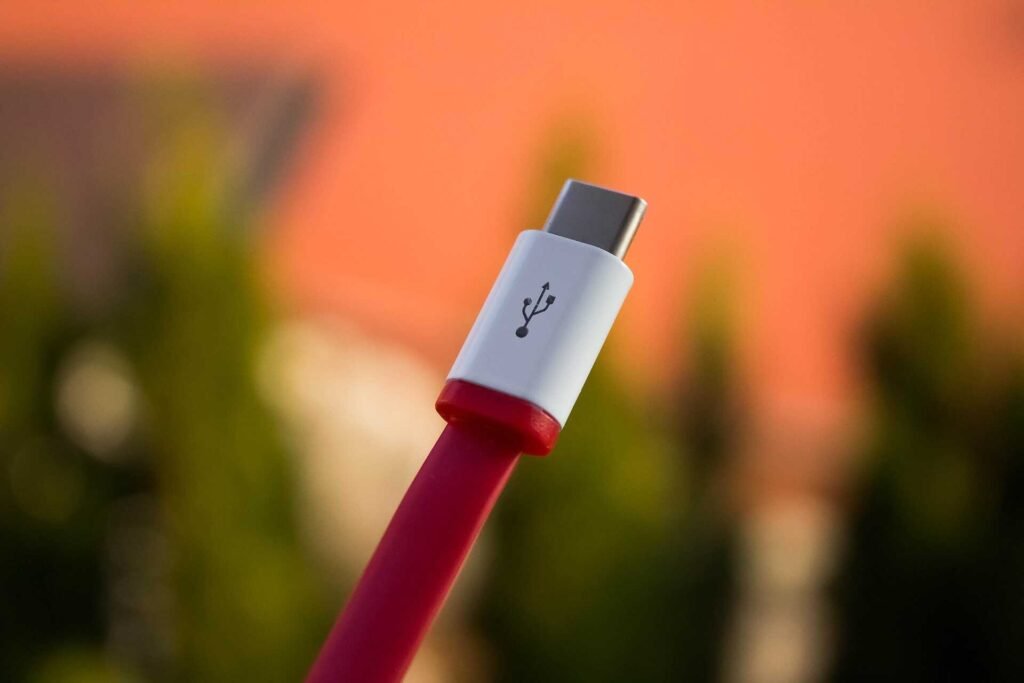 A usb type c red cable on a blurry background.