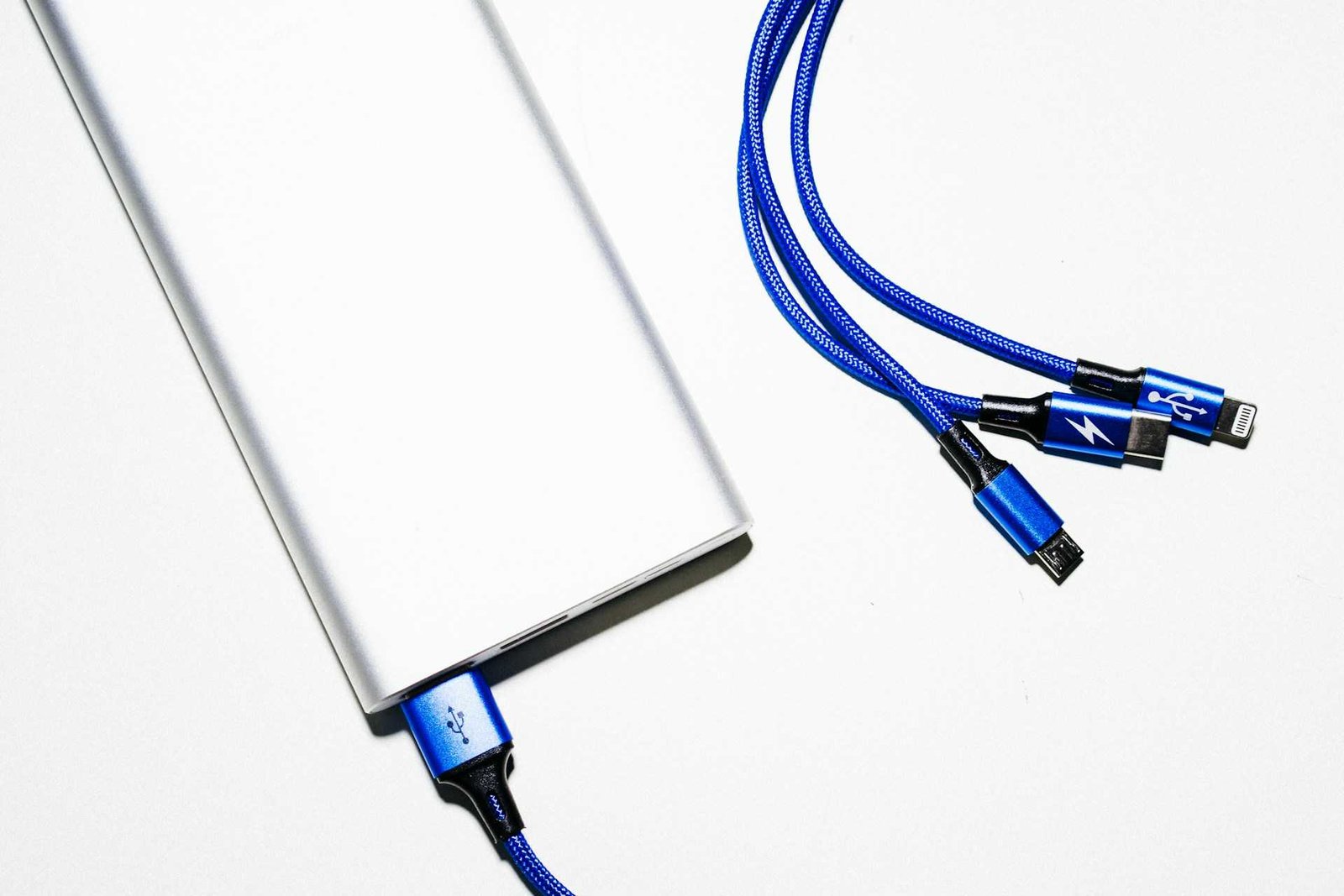 Thunderbolt and other usb cables connected to a device on white background.
