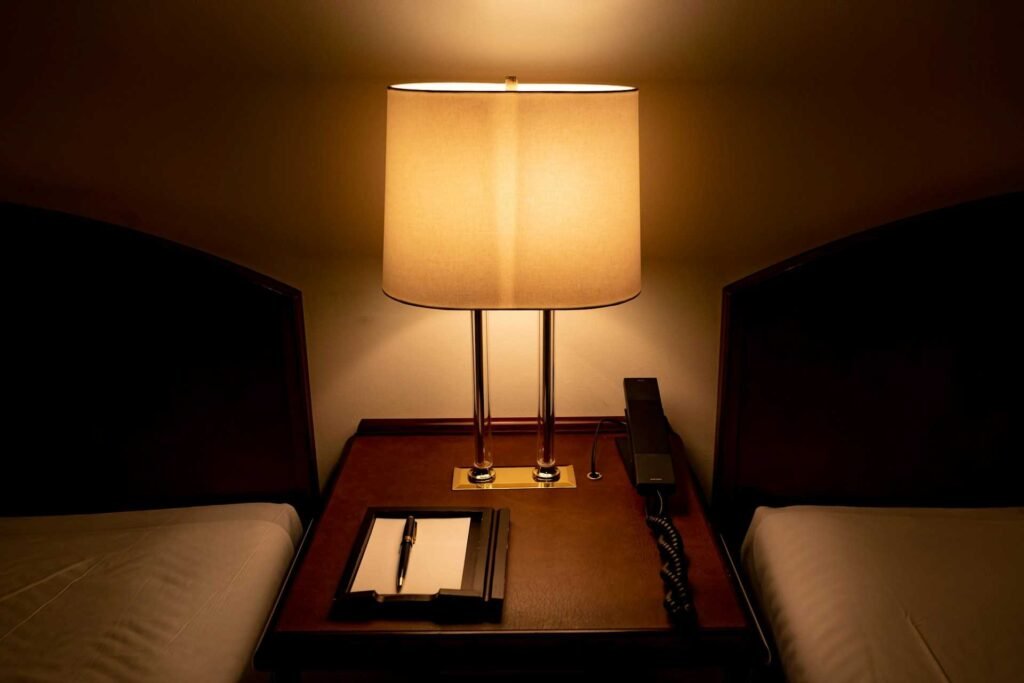 A modern bedroom lamp in between 2 beds.