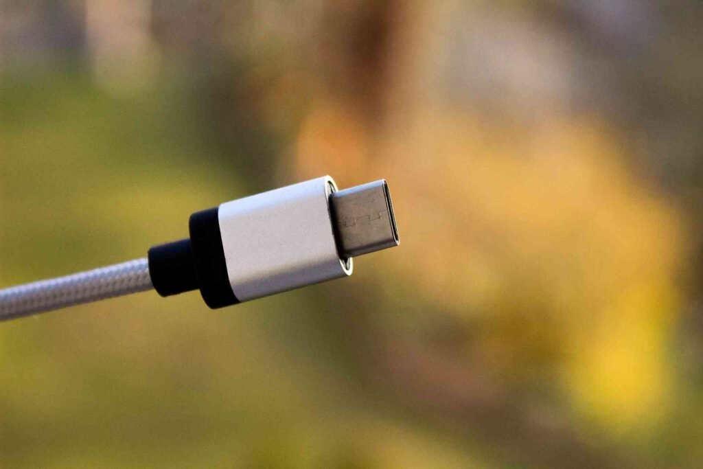 An usb c cable in the air on a blurry nature background.