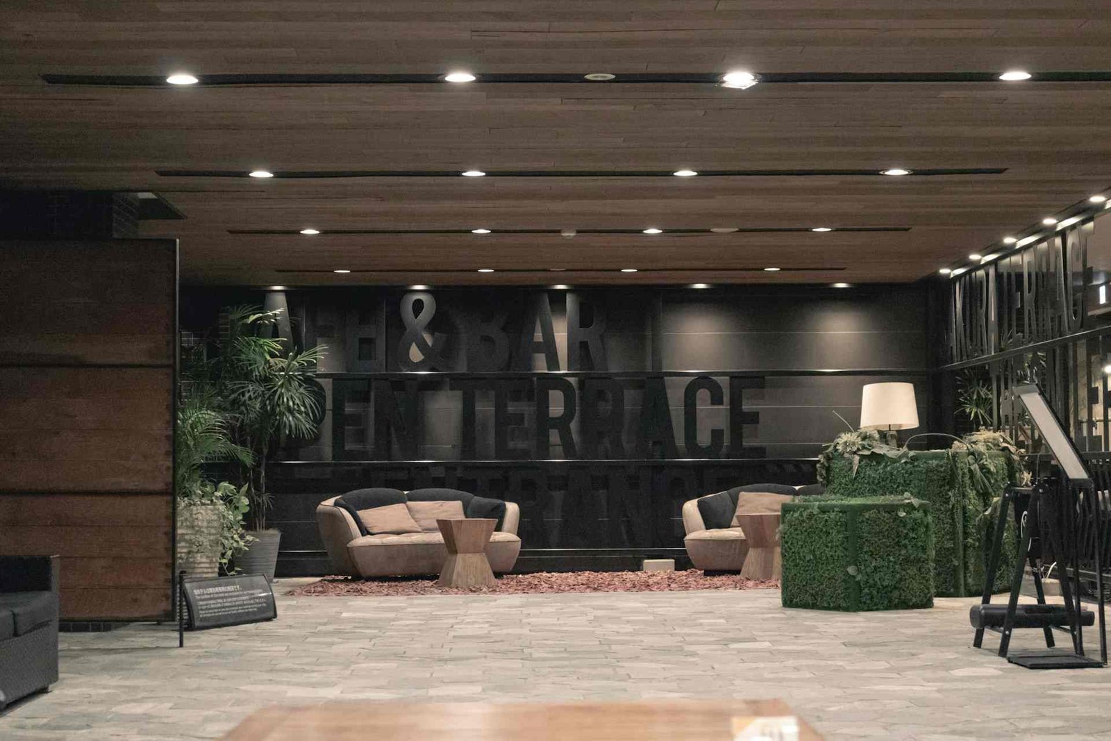 Recessed LED ceiling lights in a large lobby with couches and tables.