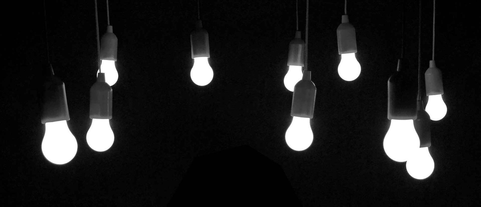 Multiple hanging LED lights on a dark background.