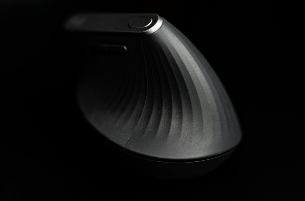The back of a black vertical mouse on a dark background.