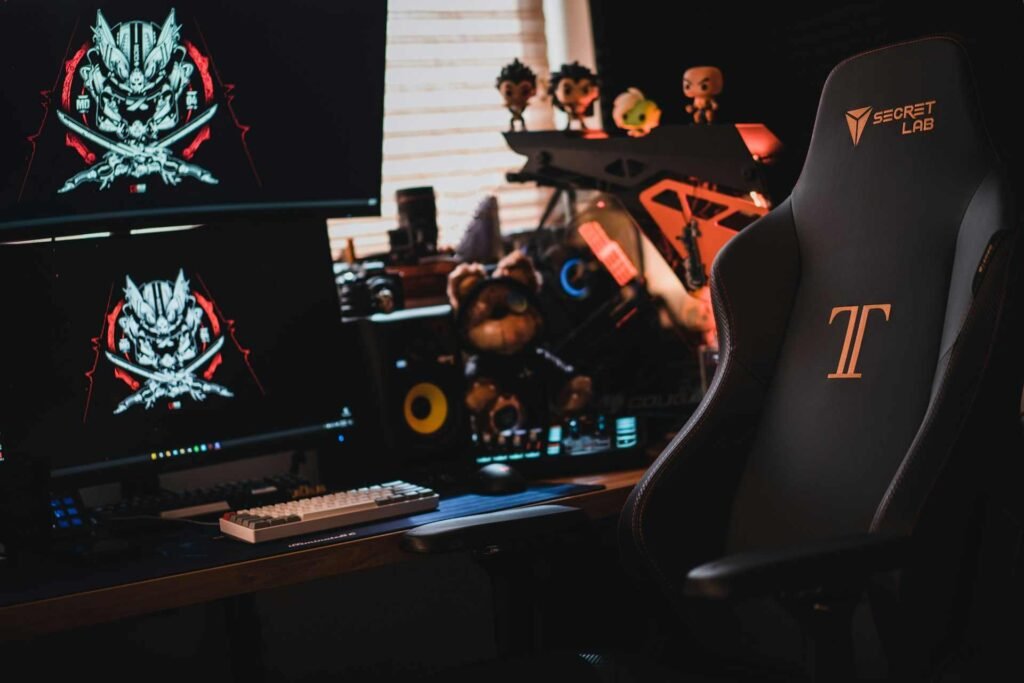A gaming chair as part of a gaming setup with 2 monitors.