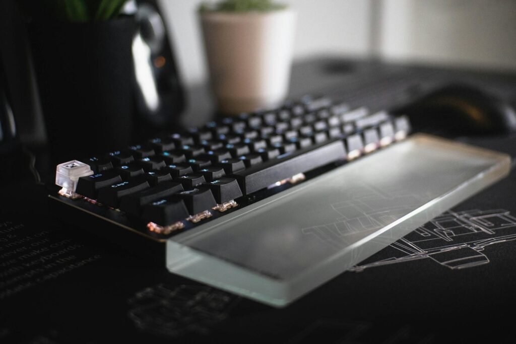 A close up of a glass wrist rest in front of a mechanical keyboard.
