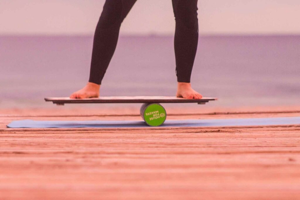 A person balancing on a board on the beach.