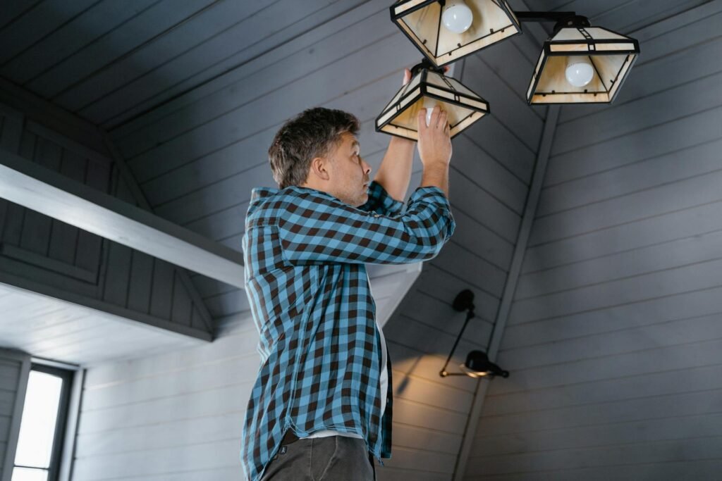 A person checking an LED light fixture.