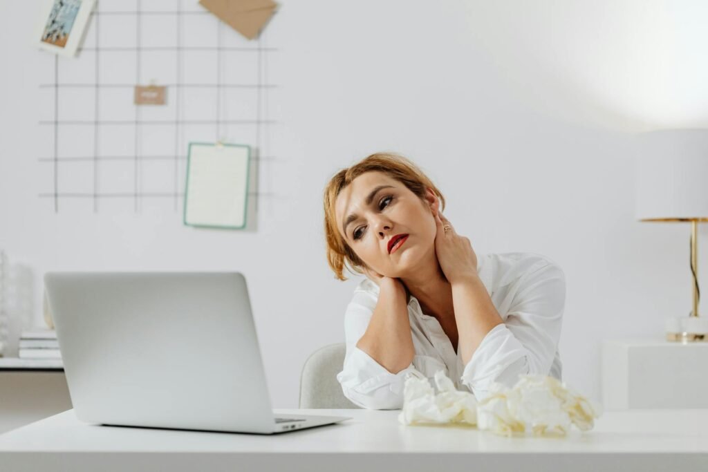 A women sitting in a chair in front of laptop with bad posture.