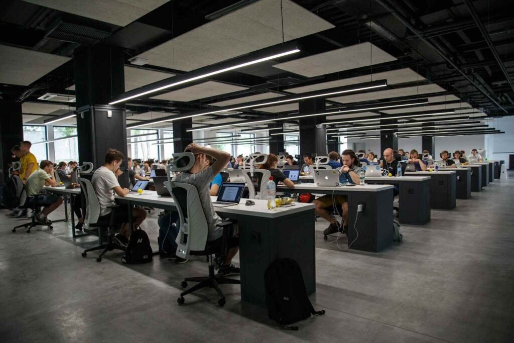 A very big open office with many people working in there.