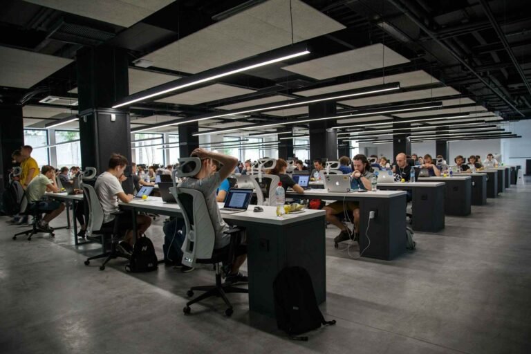 A very big open office with many people working in there.