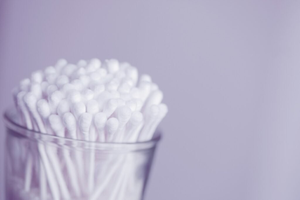 A bunch of cotton swabs in a glass.