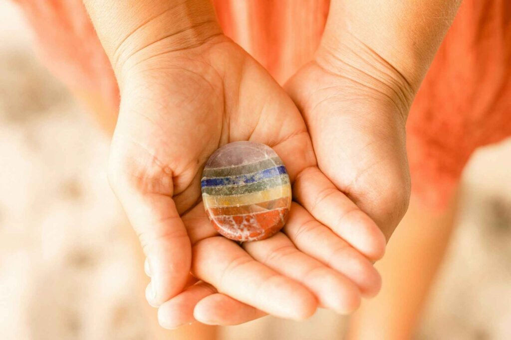 A person holding a colorful worry stone in their hands.