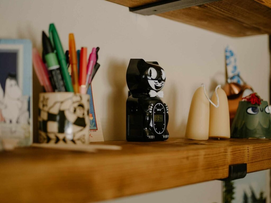 A floating wooden shelf with pens and other decorative items.