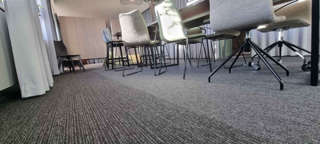 The floor perspective in an office meeting room with a grey carpet.