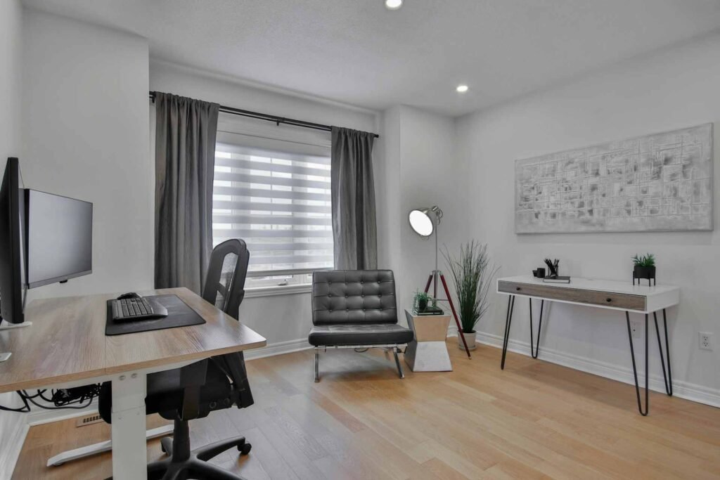 A modern office with selected furniture pieces and wooden floor.