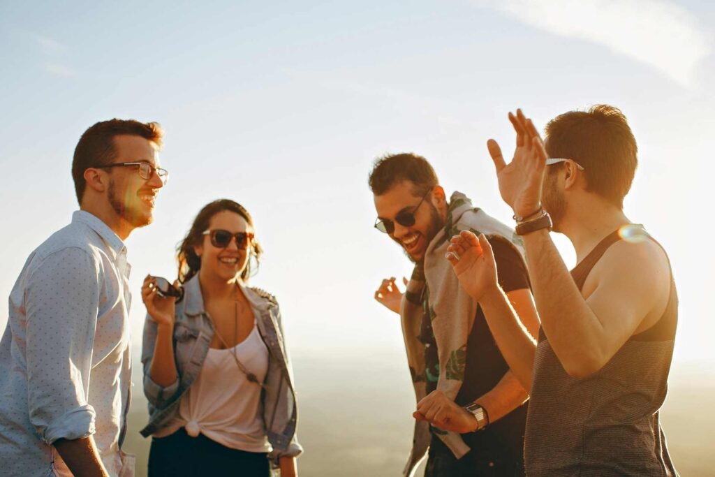 A group of four friends dancing together in sunny weather.